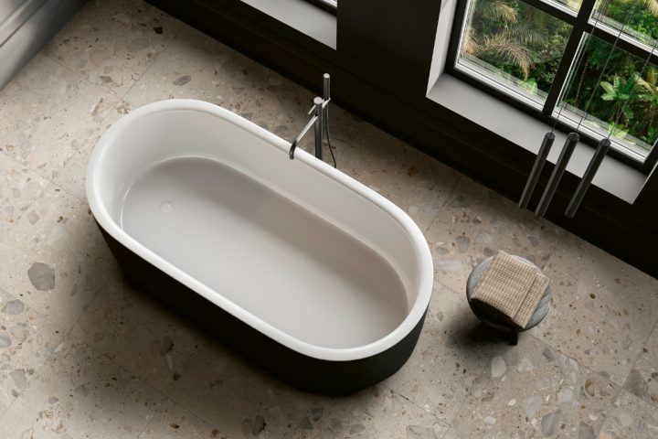 Top view of dark home bathroom interior with bathtub and accessories, grey concrete floor. Bathing corner in modern apartment. Panoramic window on tropics. 3D rendering